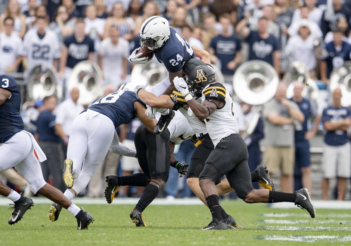 Penn State running back Miles Sanders tries to leap over Appalachian State defenders during the Saturday, Sept. 1, 2018 game at Beaver Stadium.