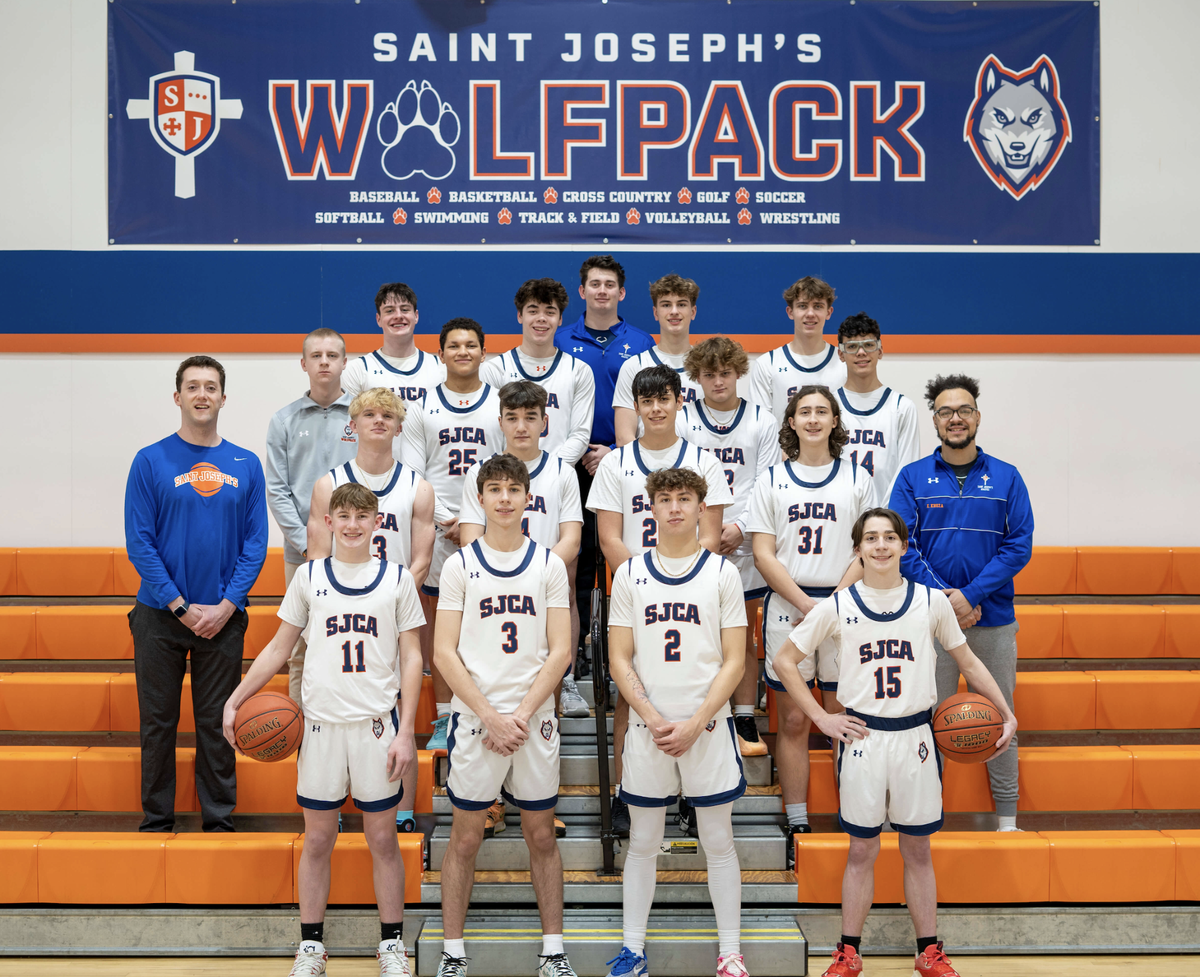 The Saint Joseph’s Catholic Academy boys basketball team poses for a group picture with coaches.