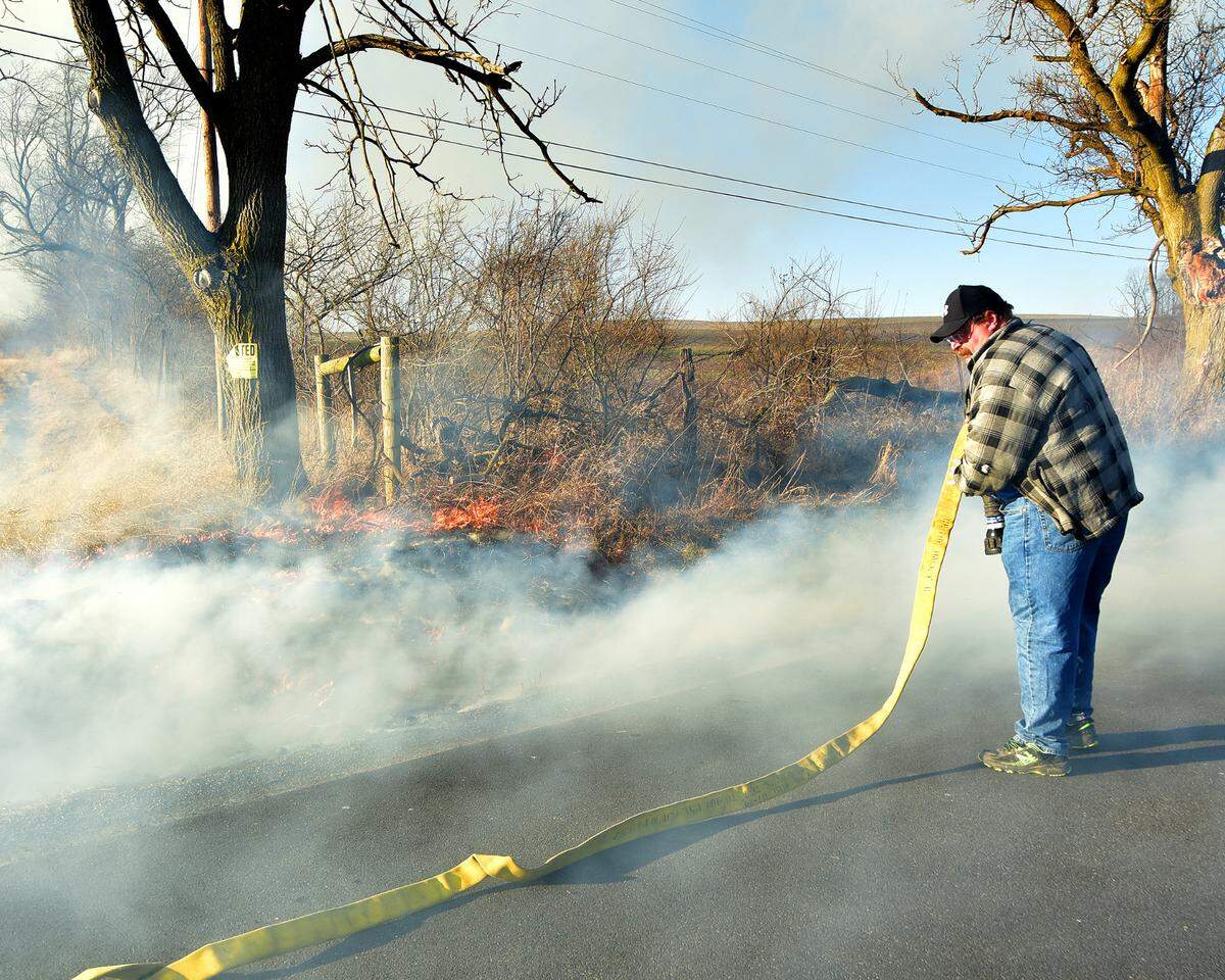 Centre Hall firefighters get ready to put water on the fire that has just reached the fence row on Sunday, Feb. 26, 2023 in Potter Township.