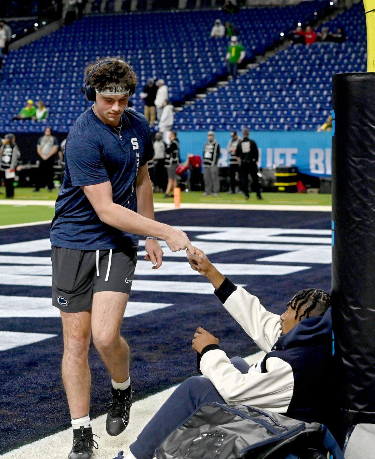 Penn State quarterback Drew Allar greets running back Nick Singleton as he walks out for his first set of warmups before the Big Ten Championship game at Lucas Oil Stadium on Saturday, Dec. 7, 2024.