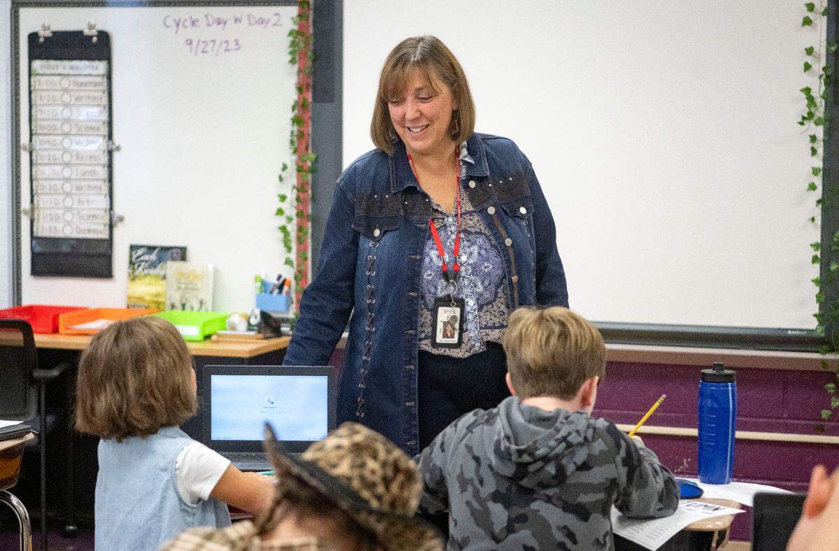 Marion Walker Elementary school principal Karen Krisch chats with students as they work on a writing assignment on Wednesday, Sept. 27, 2023.