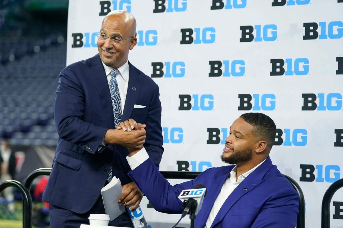 Penn State head coach James Franklin talks with defensive tackle PJ Mustipher during an NCAA college football news conference at the Big Ten Conference media days, at Lucas Oil Stadium, Wednesday, July 27, 2022, in Indianapolis.