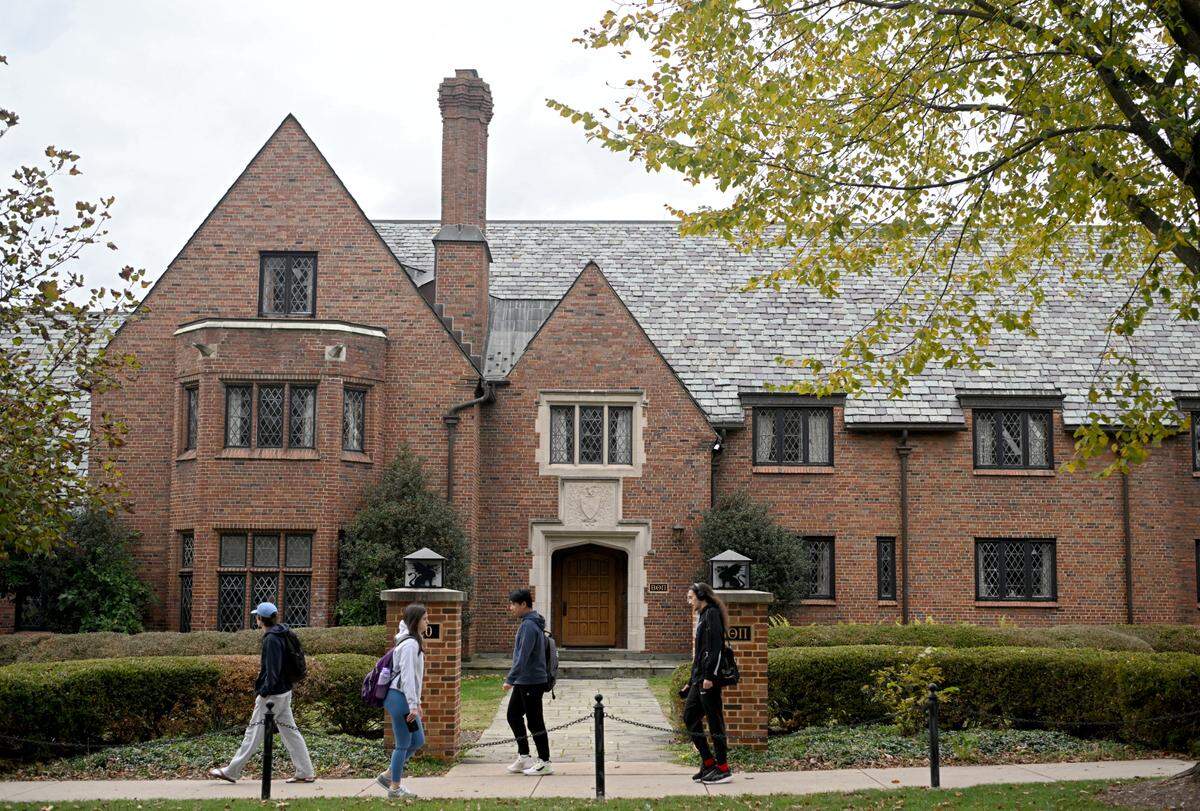 Pedestrians pass the former Beta Theta Pi house at 220 North Burrowes Road on the Penn State campus on Oct. 18, 2023.