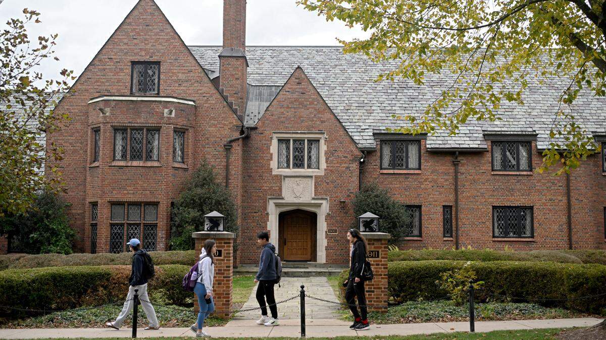 Pedestrians pass the former Beta Theta Pi house at 220 N. Burrowes Road on the Penn State campus on Oct. 18, 2023.