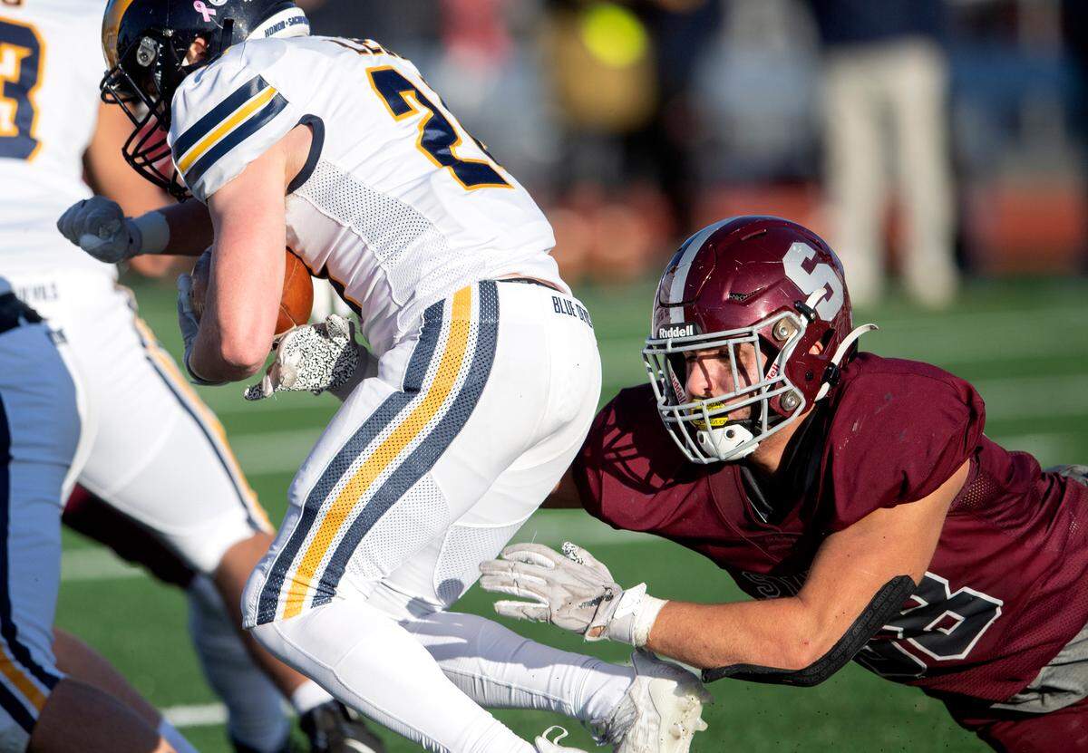 State College’s Stephen Scourtis dives to stop Mt. Lebanon’s ball carrier during the PIAA class 6A semifinal game on Saturday, Dec. 4, 2021 at Mansion Park. Mt. Lebanon won, 49-28.