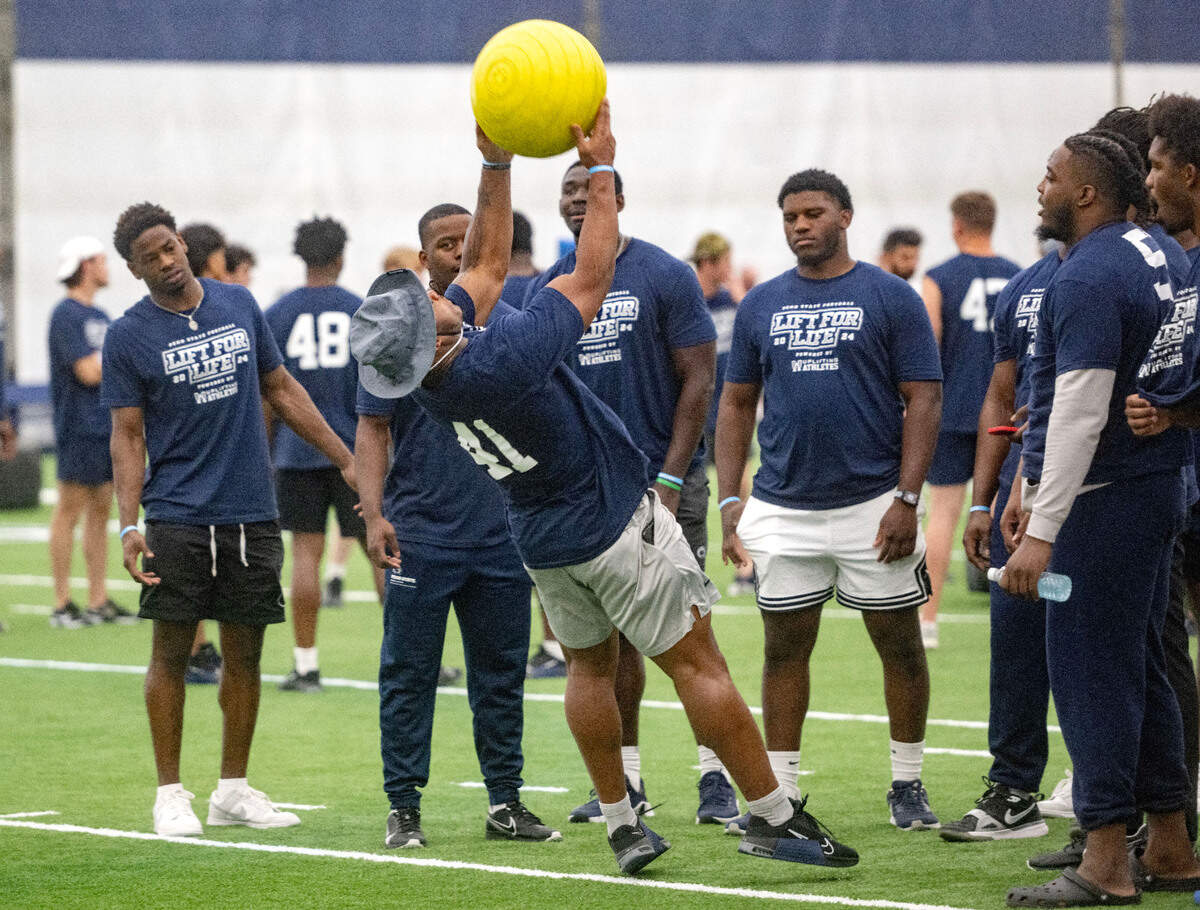 Penn State linebacker Kobe King throws a weighted ball over his head during the 21st Annual Lift for Life to benefit Uplifting Athletes on Thursday, June 13, 2024 in Holuba Hall.