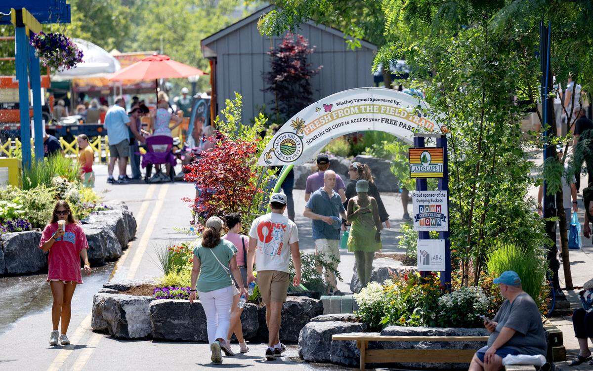 Visitors cool off in the mister during during the Central Pennsylvania Festival of the Arts on Friday, July 11, 2025.