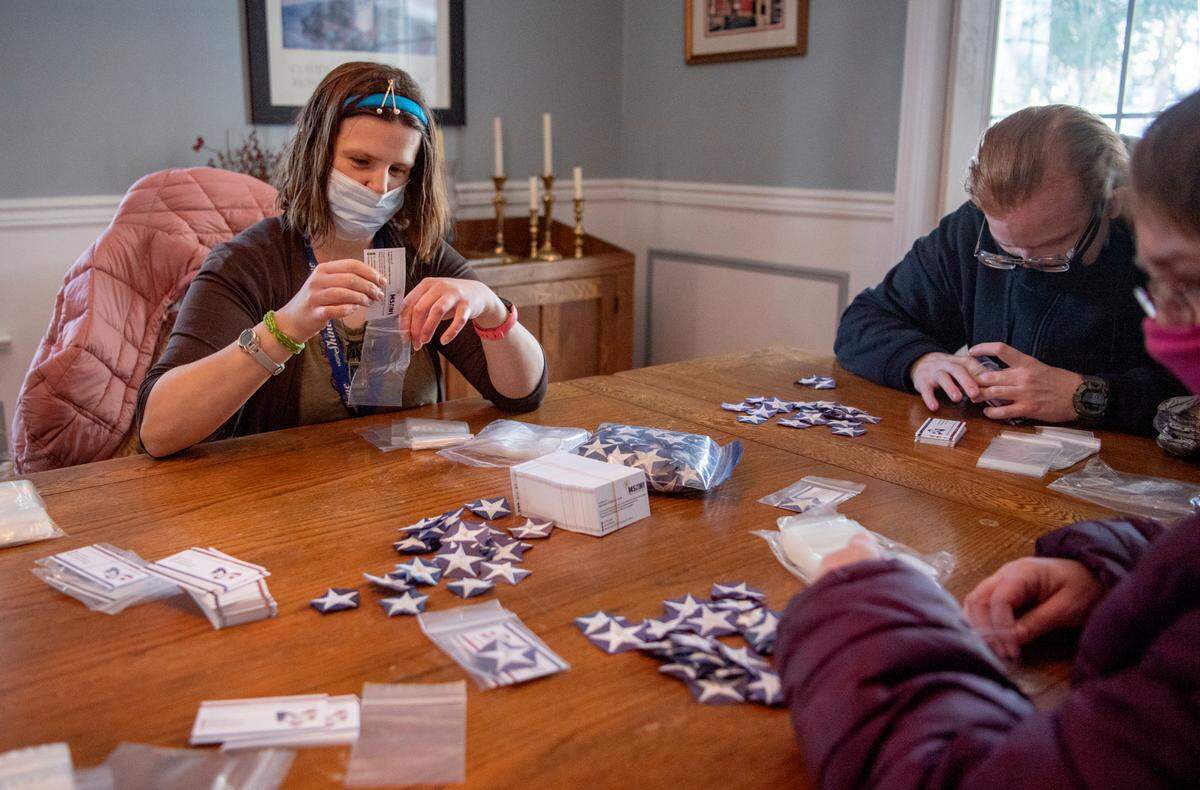 Becky Kreuter, Steven Peyton and Shelly Wright, all volunteers from Skills, help package stars on Wednesday that were cut from retired American flags and will be given to military members through A Soldier’s Hands.