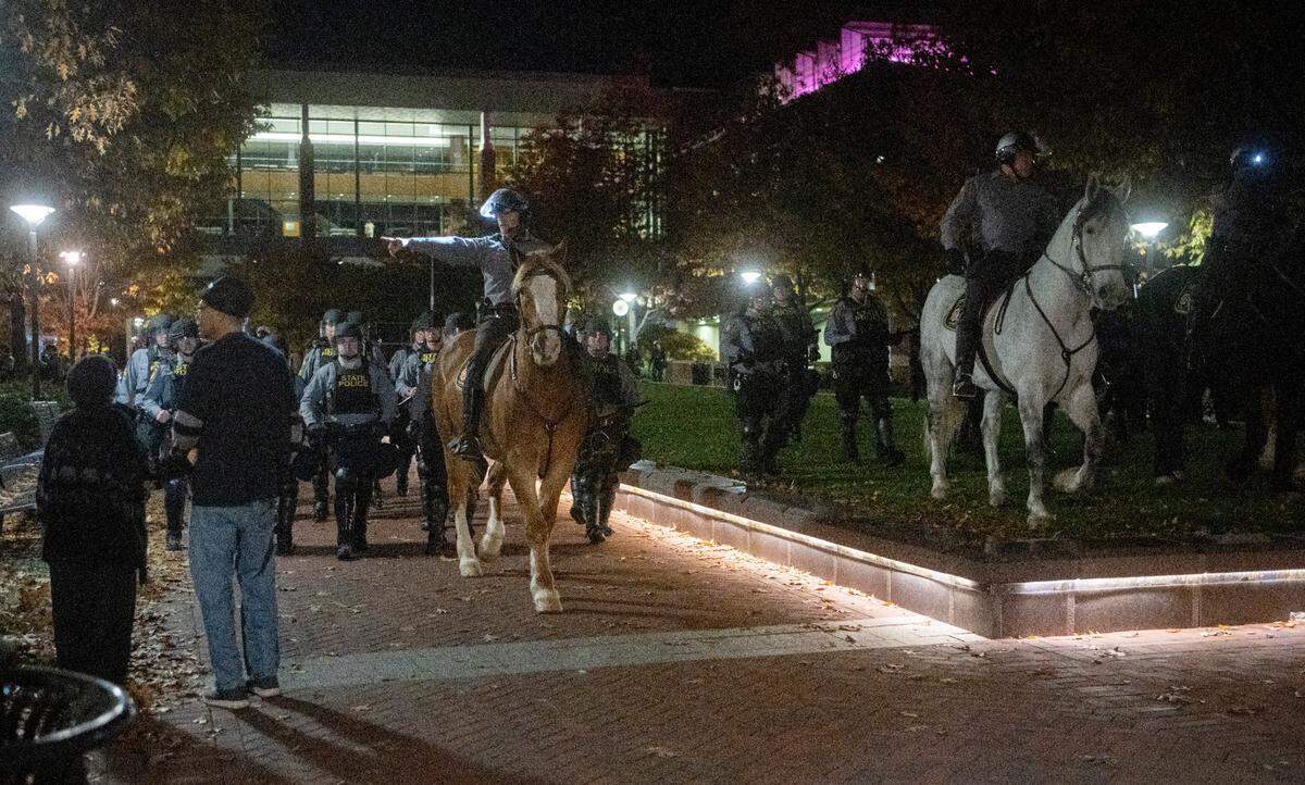 Police on horses and in riot gear work to disperse the crowd around the Thomas Building after the event was canceled on Monday, Oct. 24, 2022.