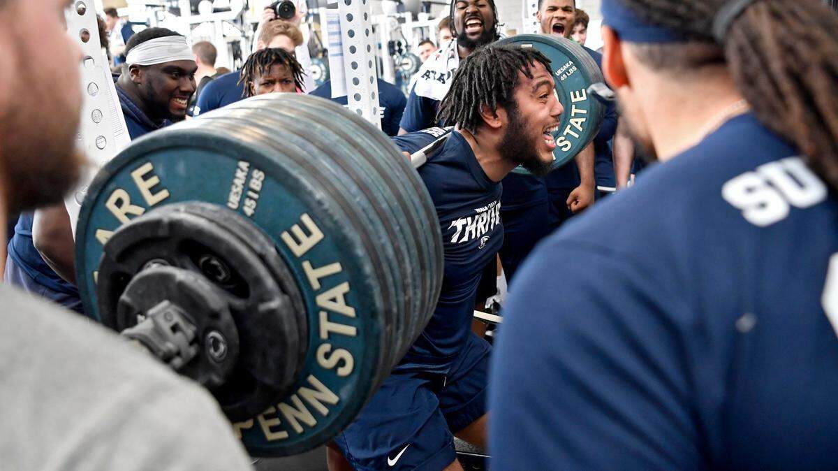 Teammates cheer on Penn State offensive lineman Des Holmes as he squats during a weight training session on Wednesday, March 4, 2020.