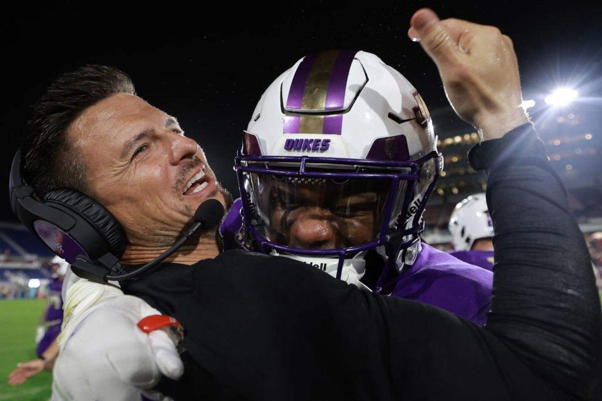 James Madison head coach Bob Chensey hugs Evan Spivey (18) after defeating the Western Kentucky Hilltoppers at FAU Stadium on Dec. 18, 2024, in Boca Raton, Florida.