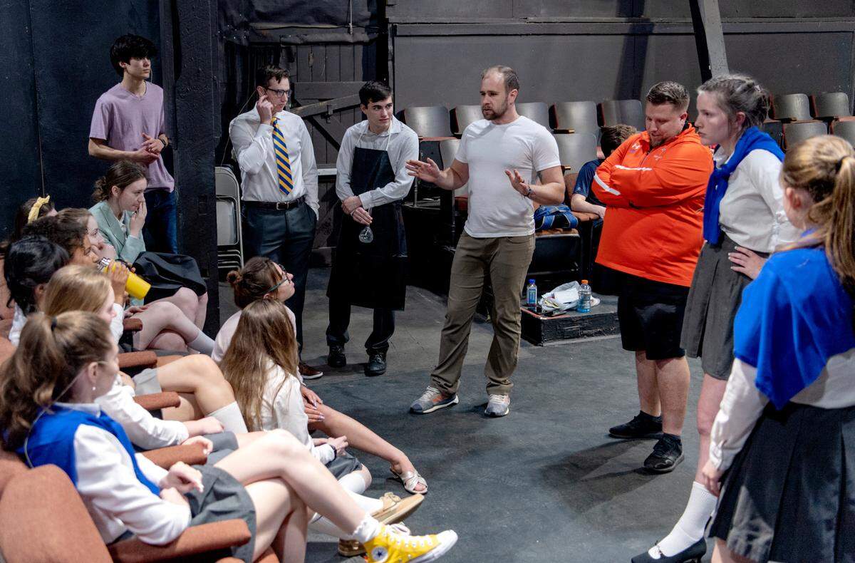 Director for Saint Joseph’s Catholic Academy’s “Emma: A Pop Musical” Joseph Hergenreder talks to the ensemble during rehearsal at the Boal Barn on Tuesday, May 3, 2022.