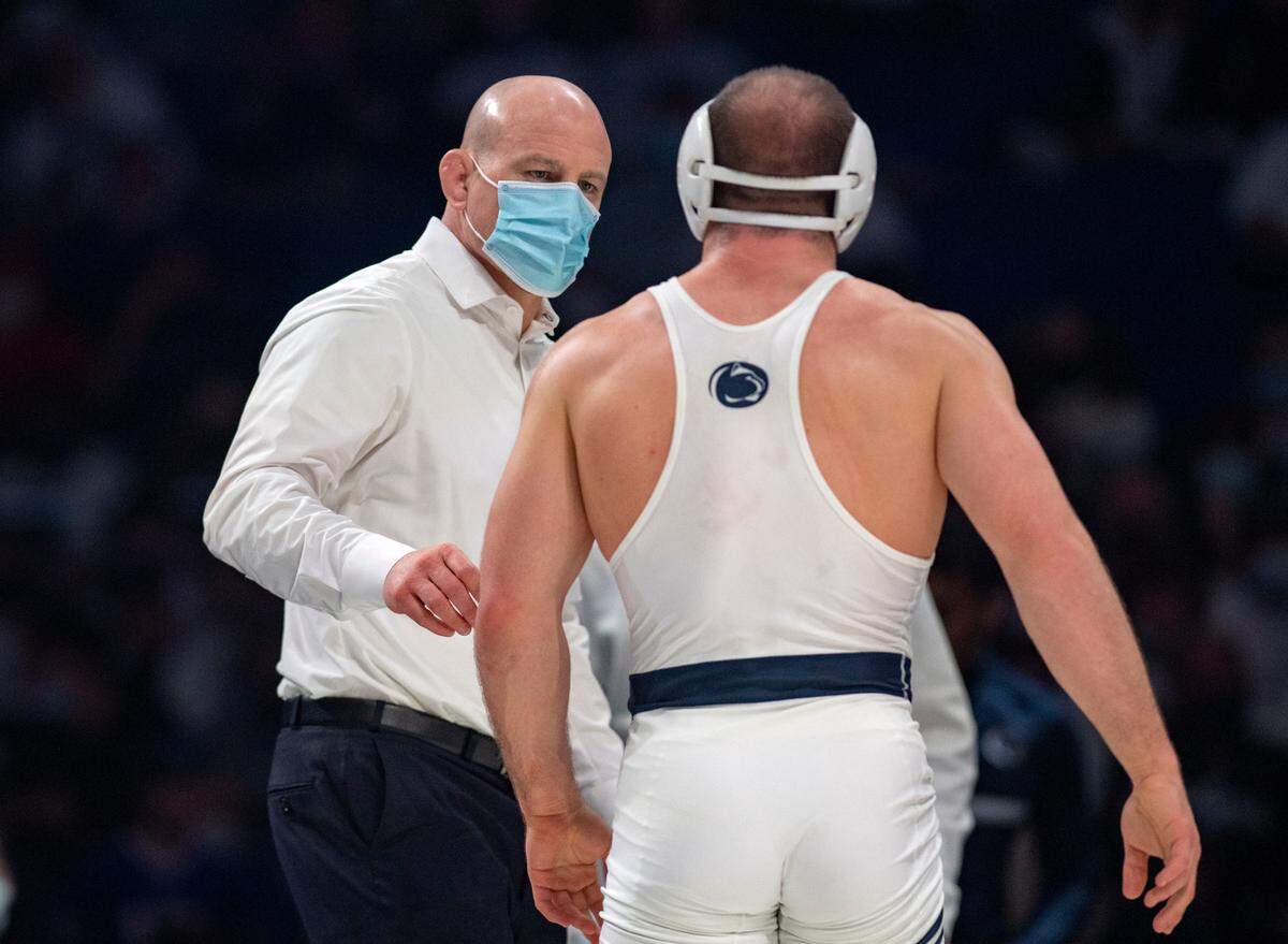 Penn State coach Cael Sanderson talks to wrestler Max Dean as a call is reviewed during the 197 lb bout of the match on Friday, Feb. 4, 2022.