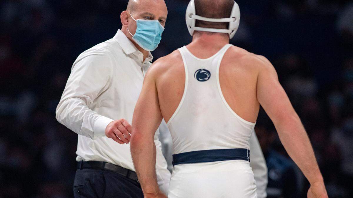 Penn State coach Cael Sanderson talks to wrestler Max Dean as a call is reviewed during the 197 lb bout of the match on Friday, Feb. 4, 2022.
