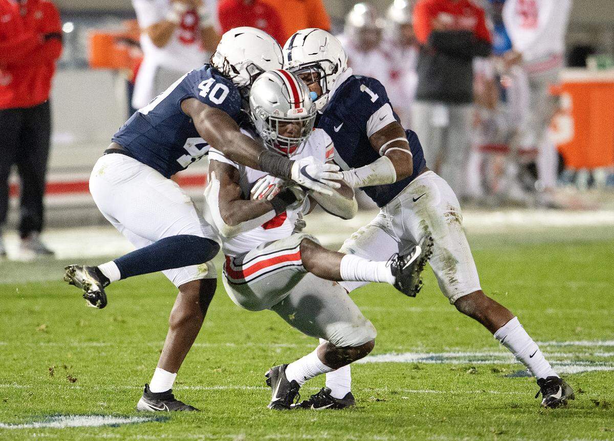 Penn State linebacker Jesse Luketa and safety Jaquan Brisker stop Ohio State’s Trey Sermon during the game on Saturday, Oct. 31, 2020 at Beaver Stadium.