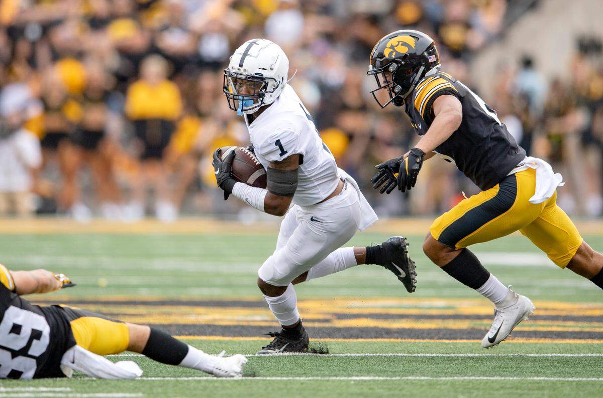 Penn State safety Jaquan Brisker intercepts the ball and cuts down the field from Iowa players during the game on Saturday, Oct. 9, 2021 at Kinnick Stadium.