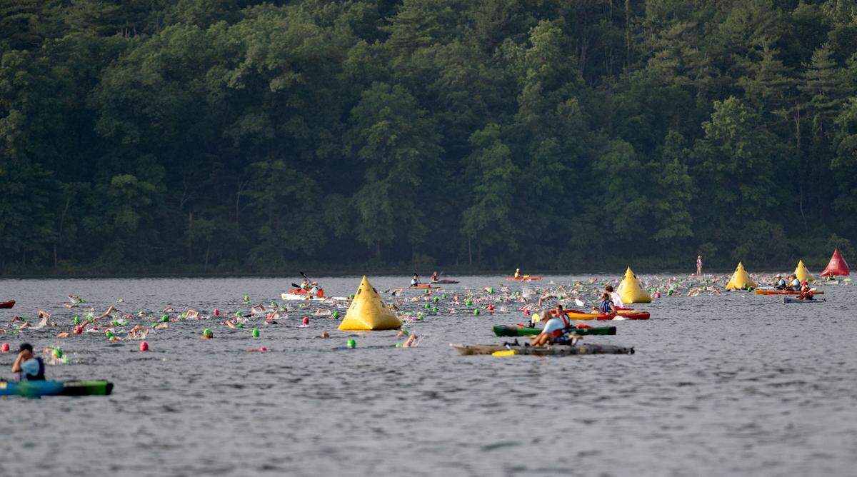 Volunteers in kayaks float along the 1.2 mile swim route for the Ironman 70.3 Pennsylvania Happy Valley on Sunday, June 30, 2024.