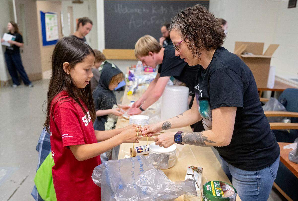 Eliana Mercedes, 10, ties a parachute onto her egg drop vessel with her mom Annette Mercedes during Astrofest on Wednesday, July 9, 2025.