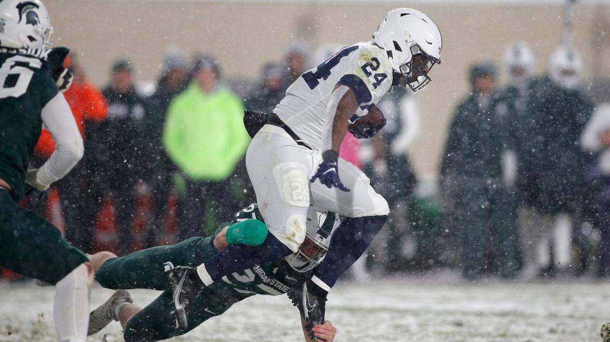 Penn State’s Keyvone Lee, right, rushes against Michigan State’s Cal Haladay during an NCAA college football game, Saturday, Nov. 27, 2021, in East Lansing, Mich. Michigan State won 30-27.