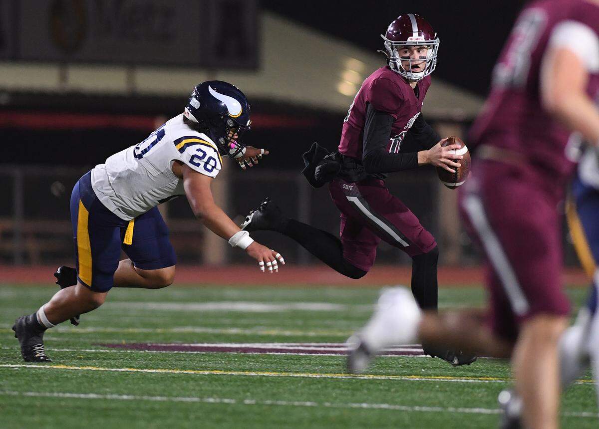 State College quarterback Connor Kulka is pressured by Central Catholic’s Manny Regus (20) in PIAA Class 6A quarterfinal action Friday, Nov. 21, 2025, at Altoona’s Mansion Park.