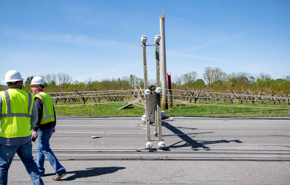 Workers assess the damage to multiple poles on West College Avenue between Whitehall Road and Bristol Avenue on Wednesday.