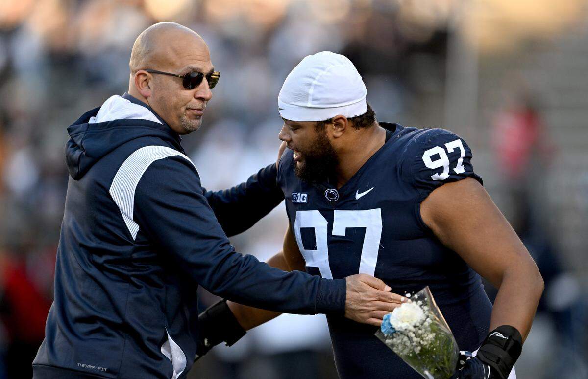 Penn State football coach James Franklin hugs senior PJ Mustipher before the game against Michigan State on Saturday, Nov. 26, 2022.
