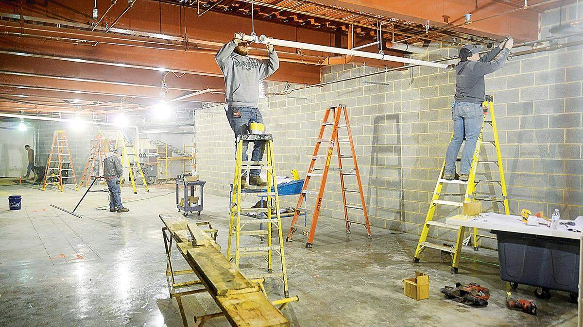 Plumbers from K & K Plumbing work on construction of the new weight room at Peoples Natural Gas Field.