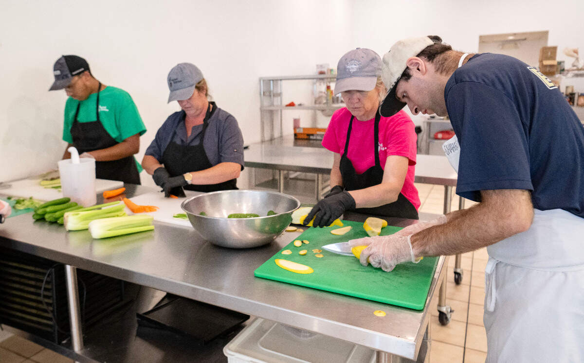 Thomas Shaheen slices squash alongside coworkers at Taproot Kitchen on Thursday, August 1, 2024.