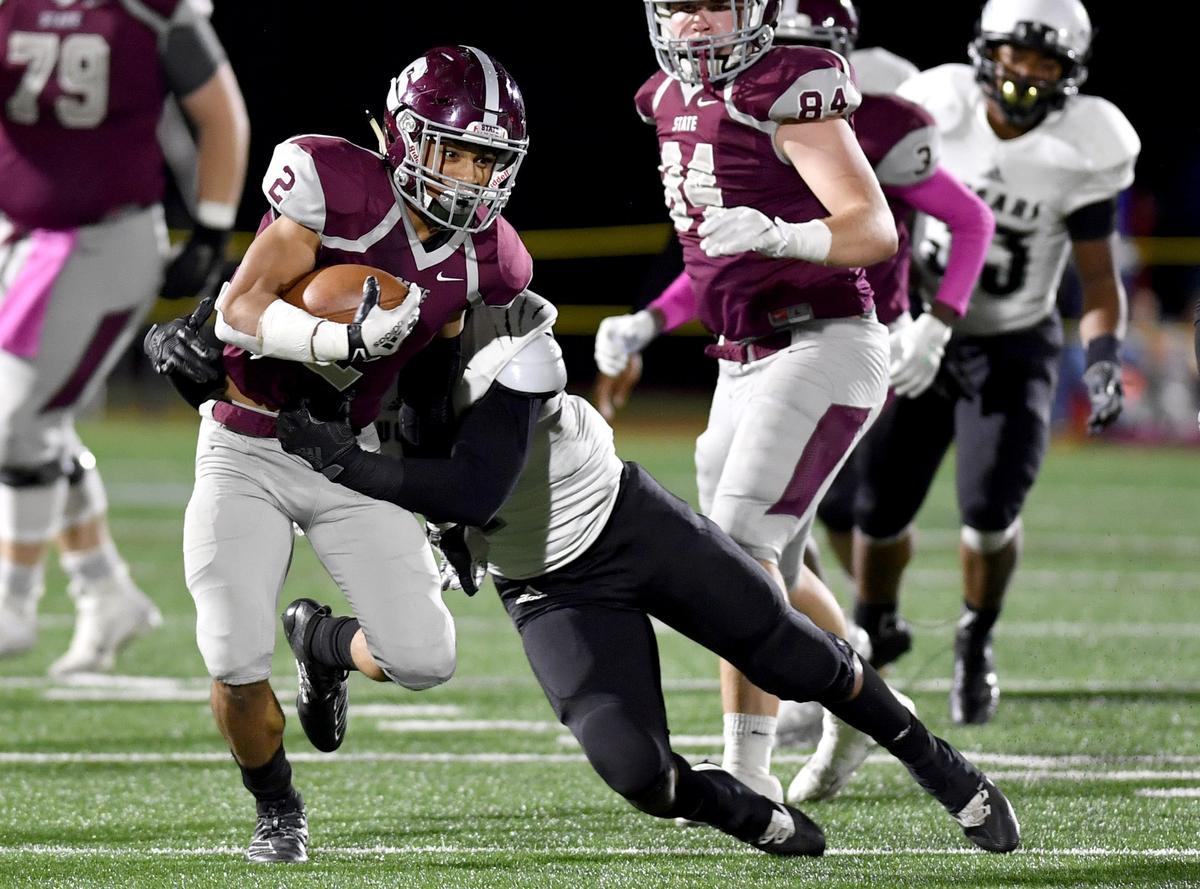 A Harrisburg defender tries to pull down State College’s Dresyn Green during the game on Friday, Oct. 4, 2019.