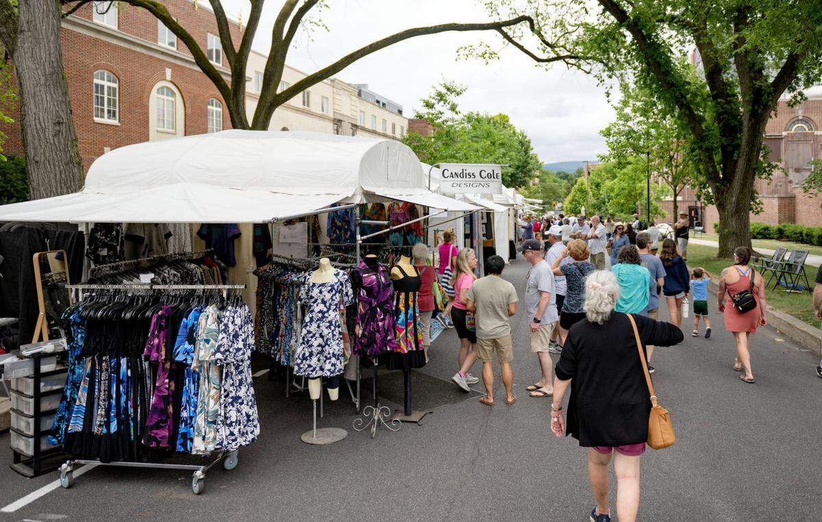 Visitors browse the artist booths along Burrowes St. at the Central Pennsylvania Festival of the Arts on Thursday, July 11, 2024.