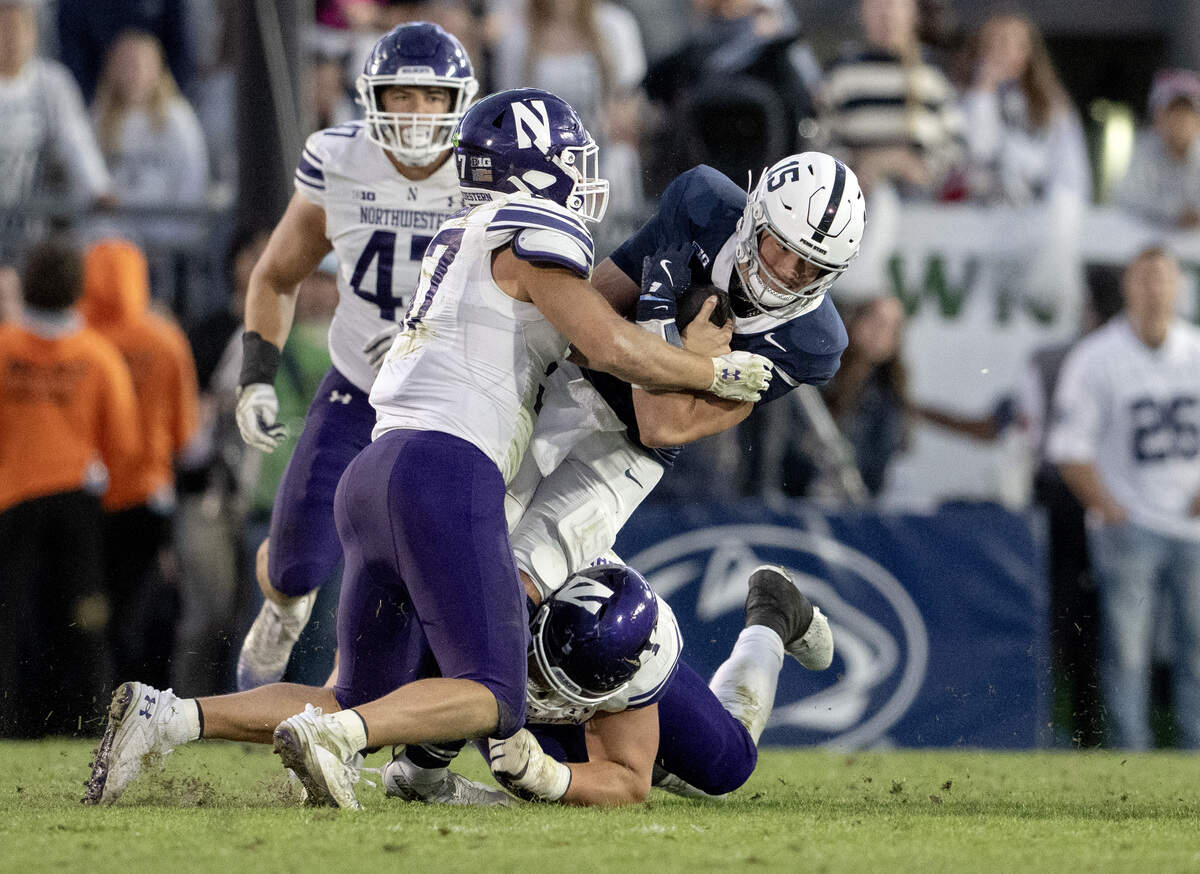 Penn State quarterback Drew Allar is stopped by Northwestern’s Mac Uihlein and Carmine Bastone during the fourth quarter of the game on Saturday, Oct. 11, 2025.  Allar was down on the field after the play.