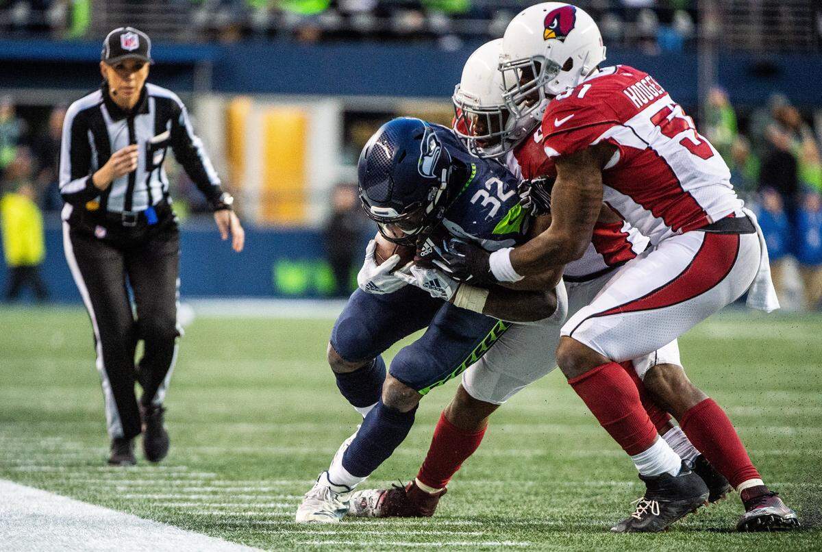 Seahawks running back Chris Carson is tackled by Cardinals linebacker Haason Reddick and Cardinals linebacker Gerald Hodges on a run in the final seconds of the fourth quarter. The Seattle Seahawks played the Arizona Cardinals in a NFL football game at CenturyLink Field in Seattle, Wash., on Sunday, Dec. 30, 2018.