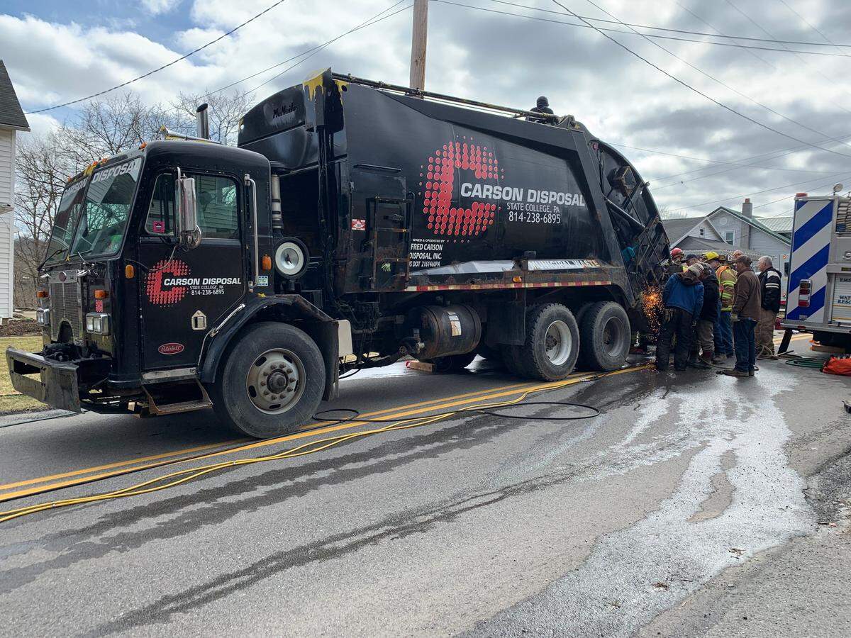 A trash collection employee whose left arm was stuck in the back of a garbage truck for nearly two hours Tuesday was transported to the hospital for treatment of moderate injuries.