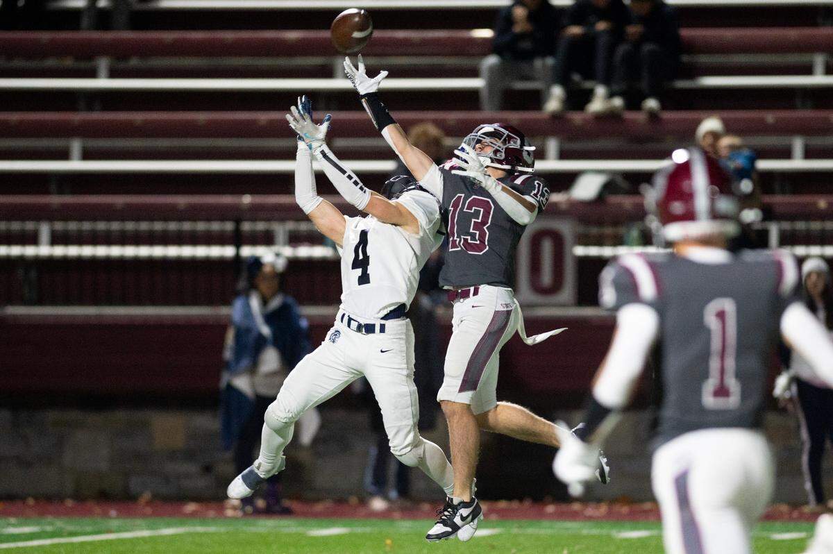 McDowell wide receiver Kameron Bastow and State High defensive back Hank Lustig reach for the ball during the football game at Memorial Field on Friday, Nov. 8, 2024.