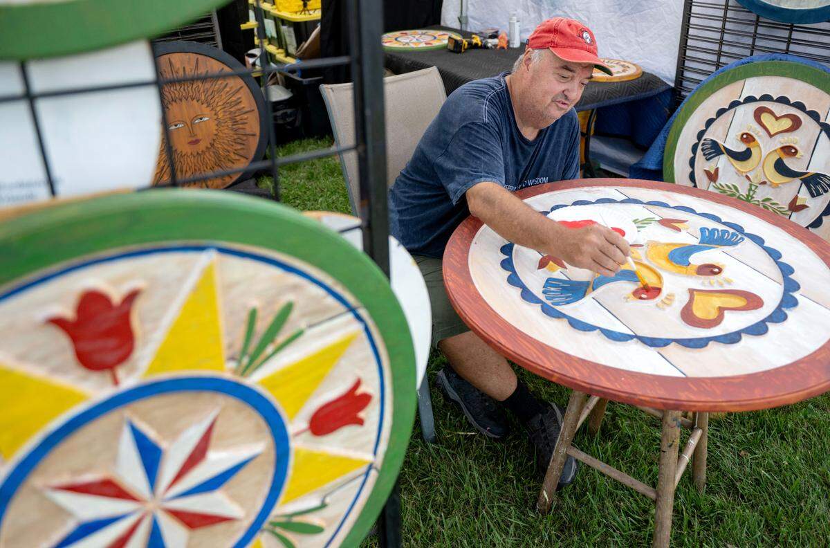 Dave Borden paints a PA Dutch Hex sign during the People’s Choice Festival of Pennsylvania on Thursday, July 10, 2025.