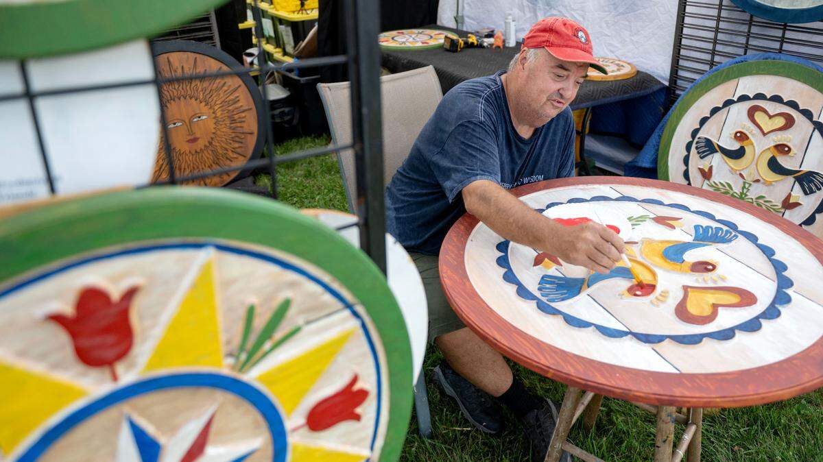 Dave Borden paints a PA Dutch Hex sign during the People’s Choice Festival of Pennsylvania on Thursday, July 10, 2025.