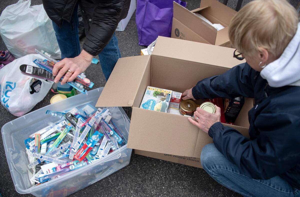 Volunteers and Salvation Baptist Church members work together to pack boxes full of food, toiletries, clothes and more to be sent to families in need in the Ukraine on Friday, March 25, 2022.
