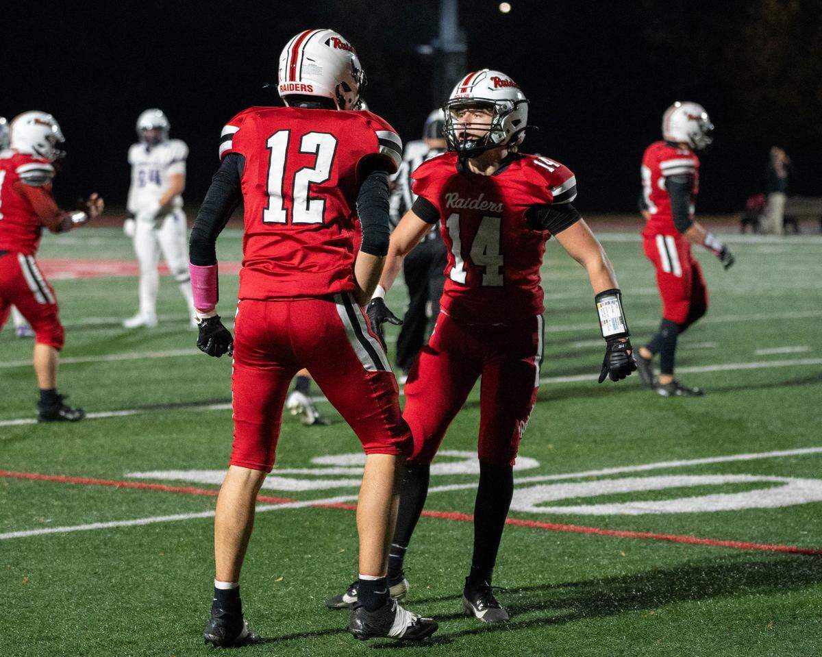 Bellefonte junior Landyn Langille (12) and sophomore Nash Weaver (14) celebrate after a play during a Friday night football game against Shamokin in Bellefonte, Pa., on Friday, Nov. 14, 2025. The Indians beat the Red Raiders 42-13 in the first round of the PIAA Class 4A championships.
