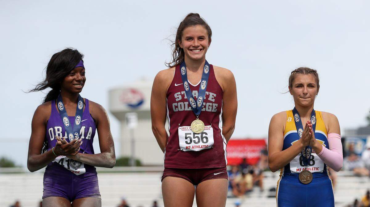 State College’s Shannon Mullin, center, receives her gold medal after finishing in first place in the girls Class 3A triple jump finals during the PIAA State Track and Field Championships held Friday at Seth Grove Stadium on the Shippensburg University campus in Shippensburg.