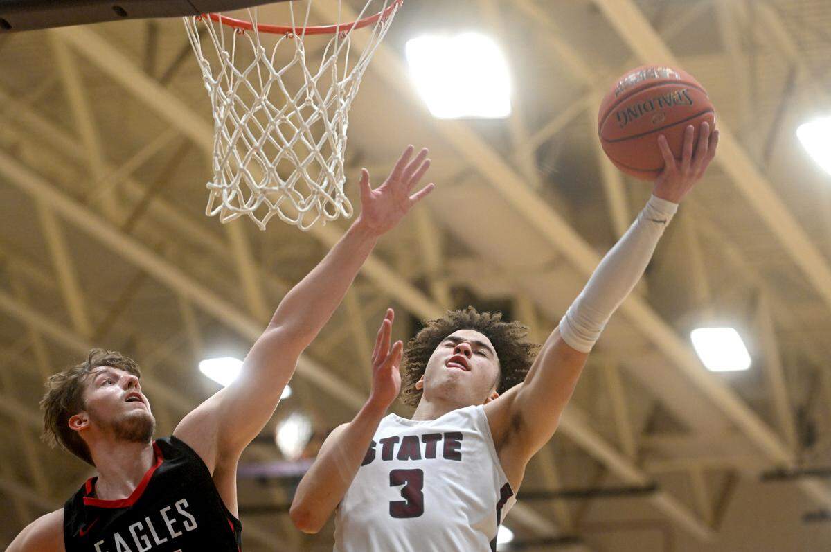 State College’s Braeden Shrewsberry gets a basket around Cumberland Valley’s Nolan Gilbert during the game on Tuesday, Feb. 7, 2023.