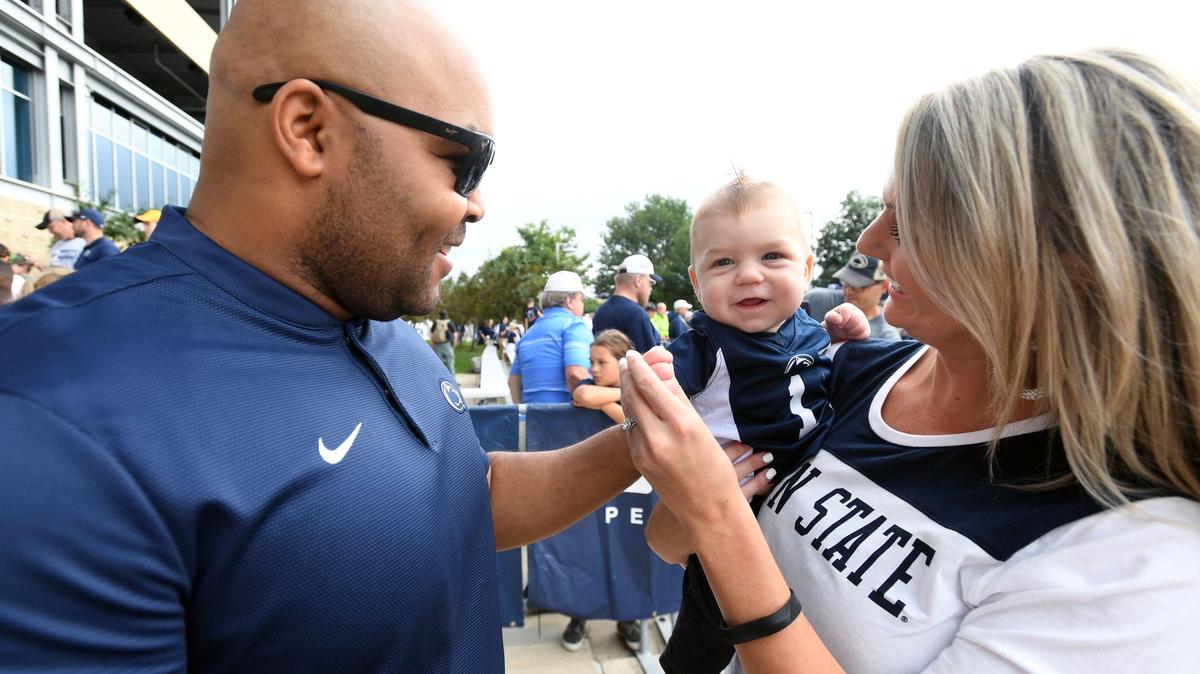 Chelsea Newsock holds her son, Braeson Newsock, five months, and greets Penn State’s Kenny Sanders on Sept. 15, 2018 at Beaver Stadium. Sanders, a 2000 McDonogh School grad, has been instrumental in recruiting players from that school.