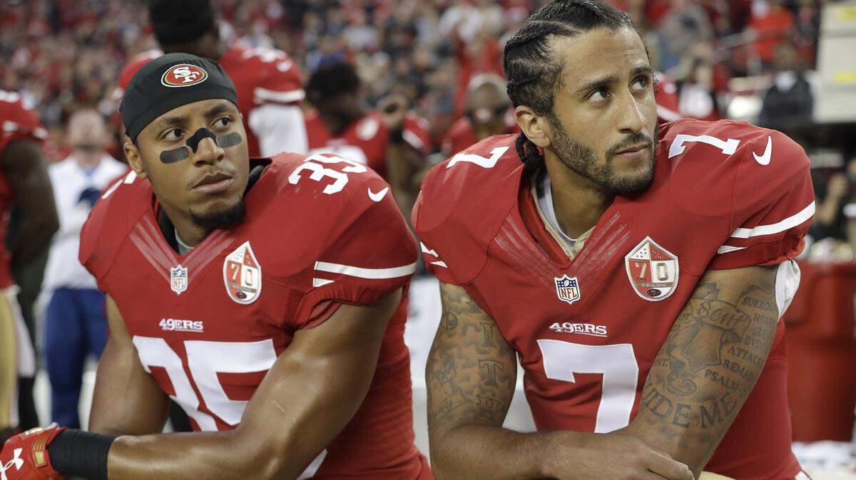 San Francisco 49ers safety Eric Reid and quarterback Colin Kaepernick kneel in September 2016 during the national anthem before an NFL football game. Kaepernick is a particularly divisive figure for Americans, according to a new poll by Penn State.