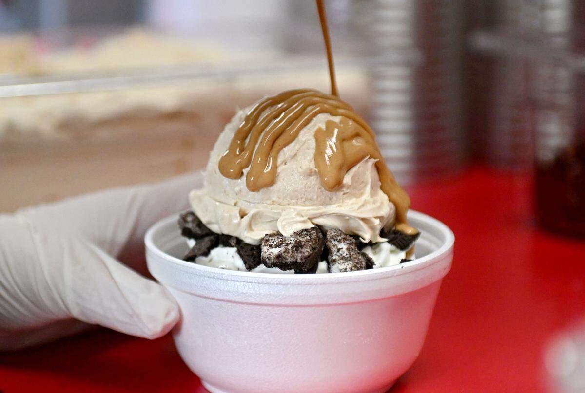 Peanut butter sauce is added on top of the peanut butter pie filling that’s piled on Oreos and soft serve for the Peanut Butter Pie Sundae at The Phoenix on Wednesday, March 25, 2026. The peanut butter pie filling is a family recipe. 