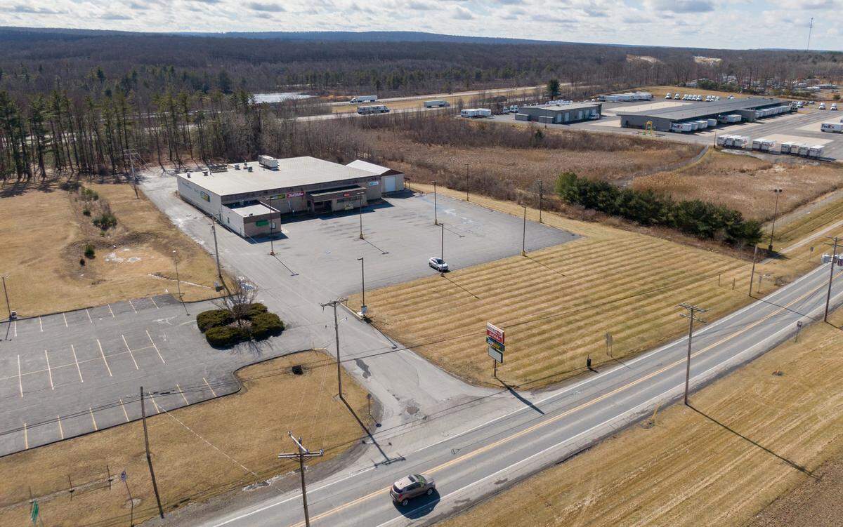 A car travels Thursday, Feb. 23, 2023, along state Route 144 in Snow Shoe Township past the empty building that formerly housed Hall’s Market, True Value, Subway and Jersey Shore State Bank.