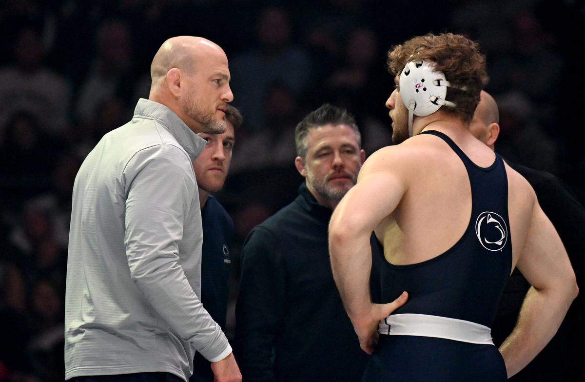 Penn State wrestling coach Cael Sanderson talks to Cole Mirasola as a call is reviewed during his 285 lb bout against Ohio State’s Nick Feldman on Friday, Feb. 13, 2026 at the Bryce Jordan Center. 