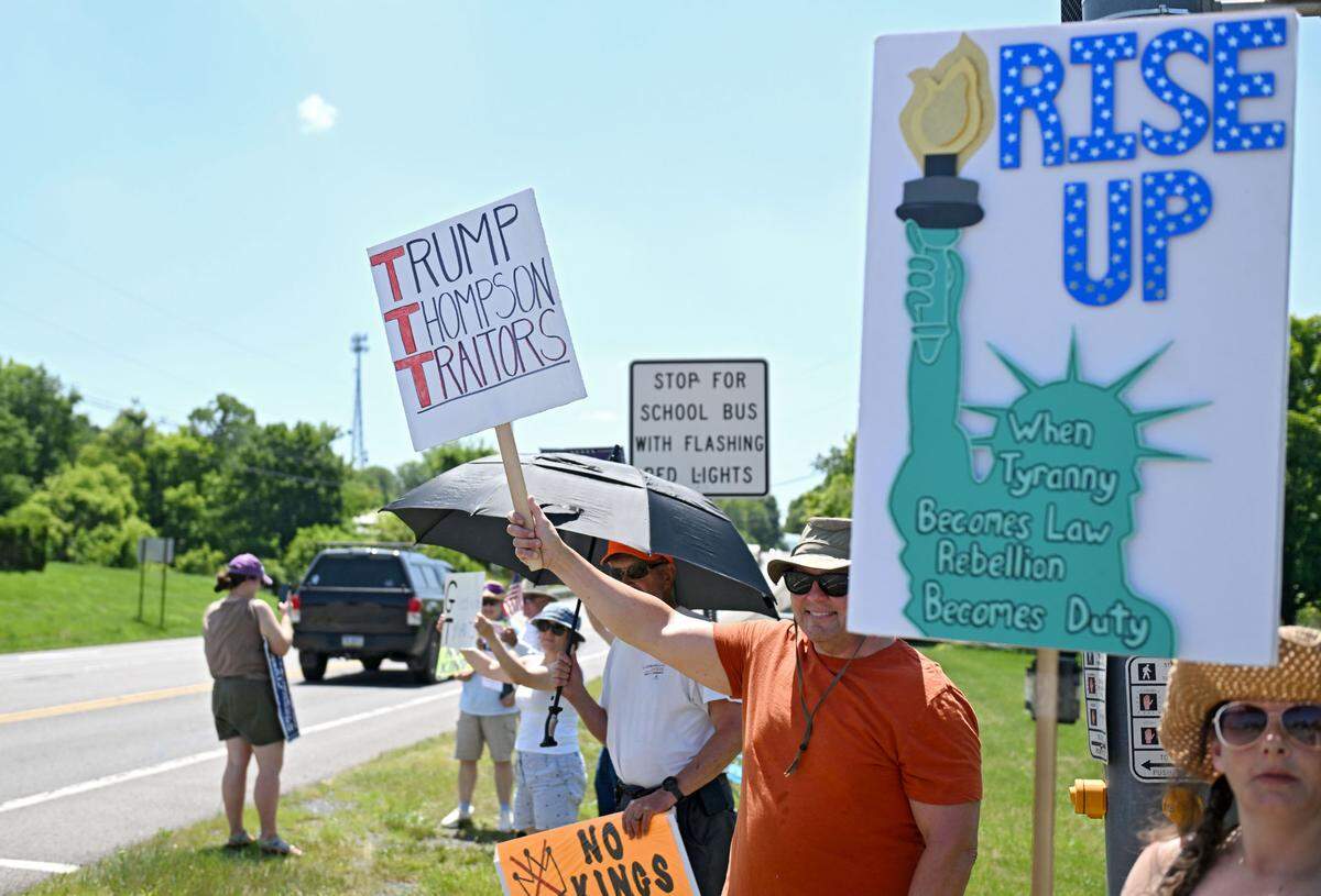 Ray Bilger holds a sign that reads “Trump Thompson Traitors” as he and other protesters gather outside of U.S. Rep. Glenn Thompson’s office on Tuesday, June 24, 2025.