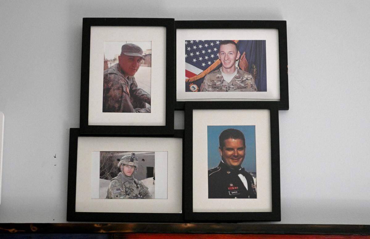 A collage on the wall of Adam Hartswick’s home honors the men who were killed on May 14, 2013, SPC William J Gilbert, SPC Cody J Towse, SPC Mitchell K Daehling, and SFC Jeffrey C Baker.