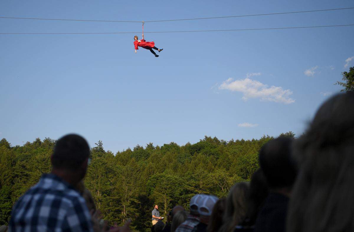 Thayne Riddle waves to the crowd as he zip lines over for the Grace Prep graduation on Friday, June 2, 2023 at Camp Kanesatake.