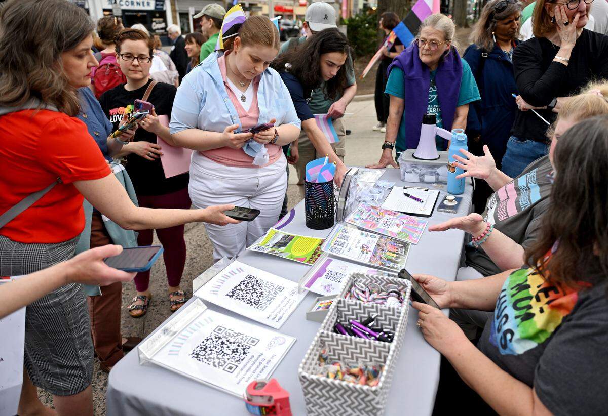 People scan QR codes to sign petitions to protect trans rights during the  Transgender Day of Visibility rally hosted by Centre LGBT+ on Tuesday, March 31, 2026.  