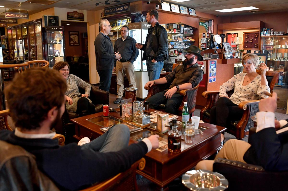 Patrons laugh as they chat in the lounge at Your Cigar Den in State College on Wednesday, Feb. 19, 2020.